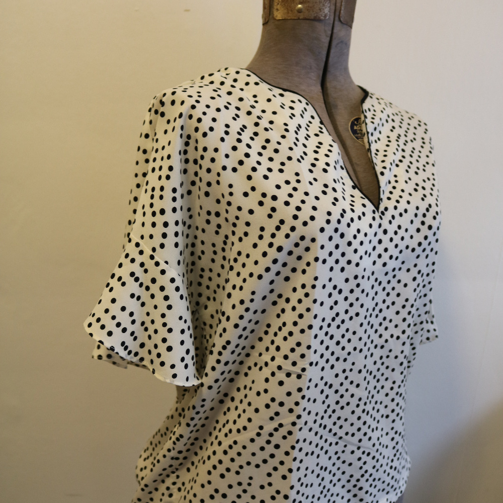 Francesca's white blouse with black polka dots
